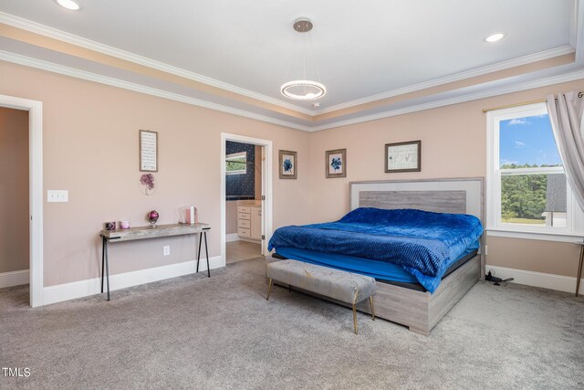 carpeted bedroom featuring a raised ceiling, ensuite bath, and crown molding