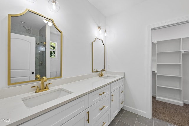 bathroom with a shower with shower door, toilet, vanity, and tile patterned flooring