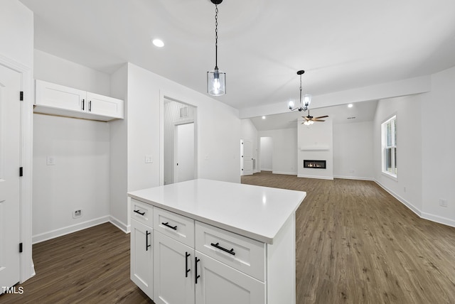 kitchen with decorative light fixtures, ceiling fan, a center island, white cabinetry, and dark hardwood / wood-style flooring