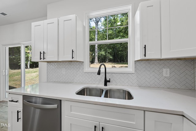 kitchen featuring white cabinets, dishwasher, sink, and plenty of natural light