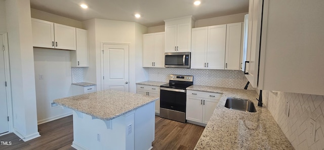 kitchen featuring white cabinets, a center island, dark hardwood / wood-style flooring, and appliances with stainless steel finishes