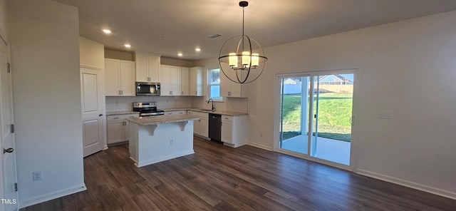 kitchen with pendant lighting, dark wood-type flooring, white cabinets, appliances with stainless steel finishes, and a kitchen island