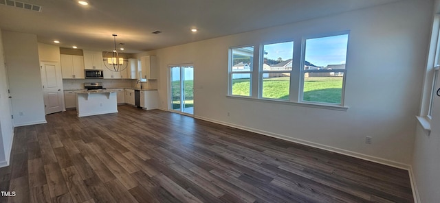 kitchen with a center island, white cabinets, decorative light fixtures, dark hardwood / wood-style flooring, and stainless steel appliances