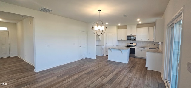 kitchen featuring white cabinets, a kitchen island, wood-type flooring, and appliances with stainless steel finishes