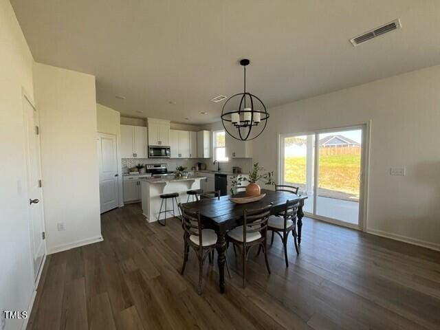 466 Saint Clair Dr, Fuquay Varina, NC 27526 - dining area with a chandelier, dark wood-style floors, and baseboards