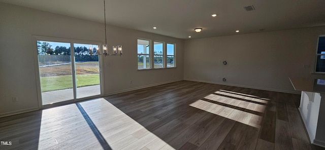 unfurnished living room featuring dark wood-style floors, plenty of natural light, and visible vents