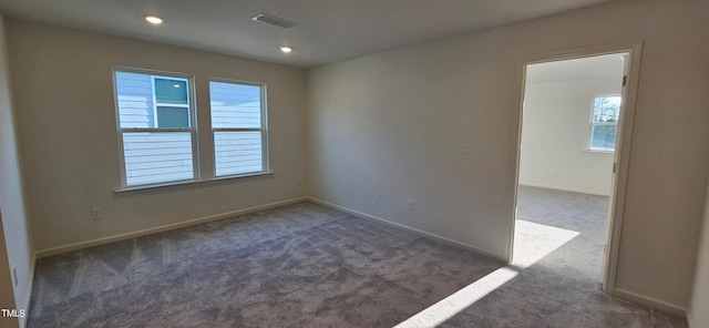 carpeted empty room featuring visible vents and baseboards