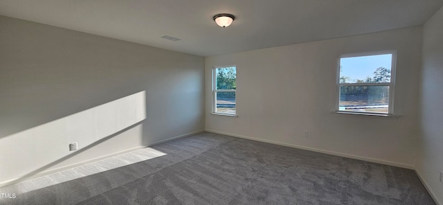 carpeted spare room featuring visible vents and baseboards