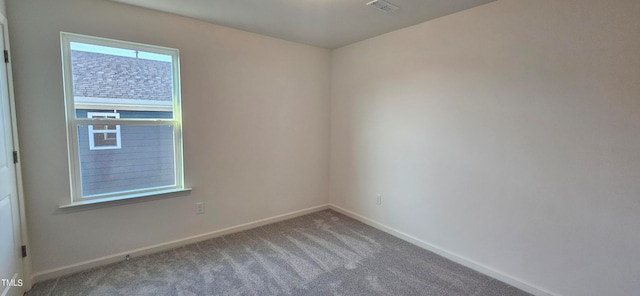 carpeted empty room featuring visible vents and baseboards