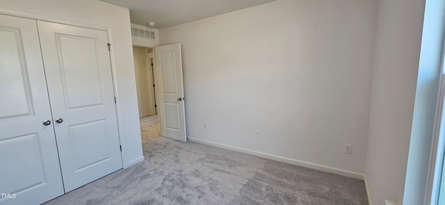 unfurnished bedroom featuring a closet, carpet flooring, visible vents, and baseboards