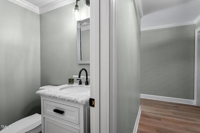 bathroom featuring hardwood / wood-style floors, vanity, toilet, and crown molding