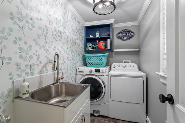 clothes washing area featuring crown molding, cabinets, separate washer and dryer, and sink