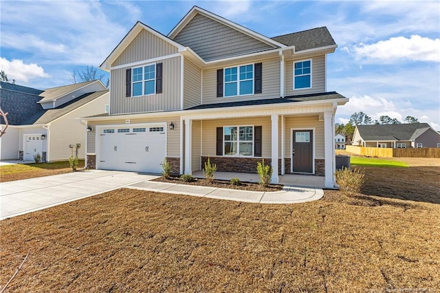 craftsman-style house with covered porch, a garage, and a front yard