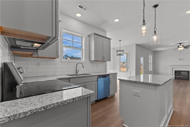 kitchen featuring hanging light fixtures, dishwasher, a center island, gray cabinets, and sink