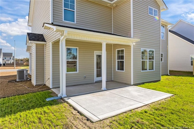 rear view of property featuring a patio, cooling unit, and a yard