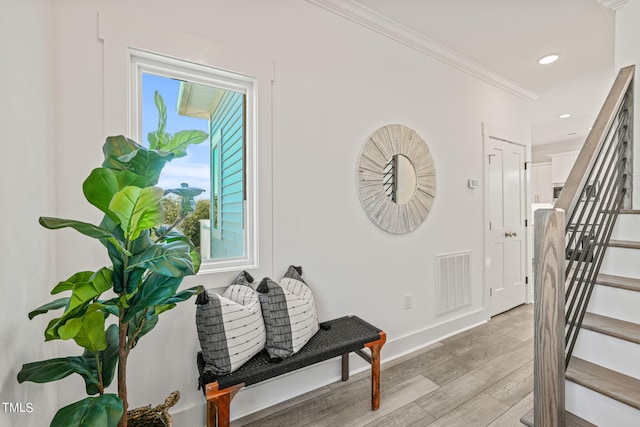 interior space with ornamental molding and light hardwood / wood-style flooring