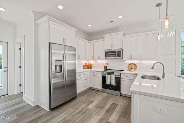 kitchen featuring white cabinetry, sink, backsplash, stainless steel appliances, and light stone countertops