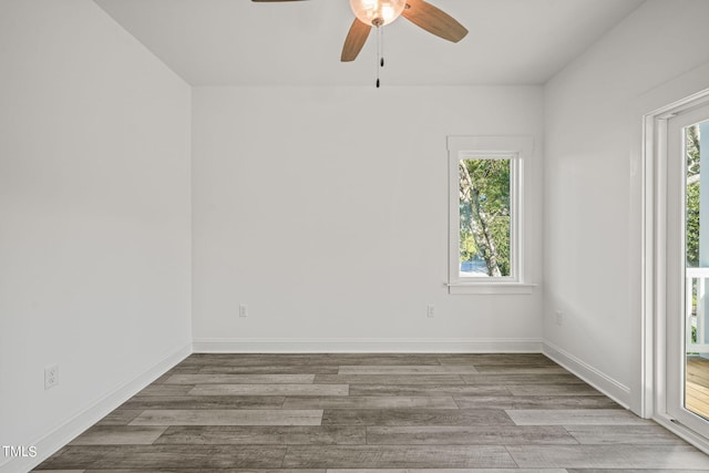 spare room with ceiling fan, a healthy amount of sunlight, and light hardwood / wood-style floors