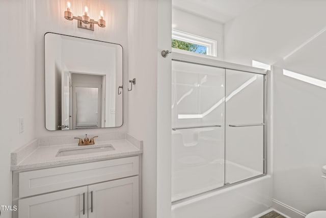 full bathroom featuring vanity, toilet, and combined bath / shower with glass door