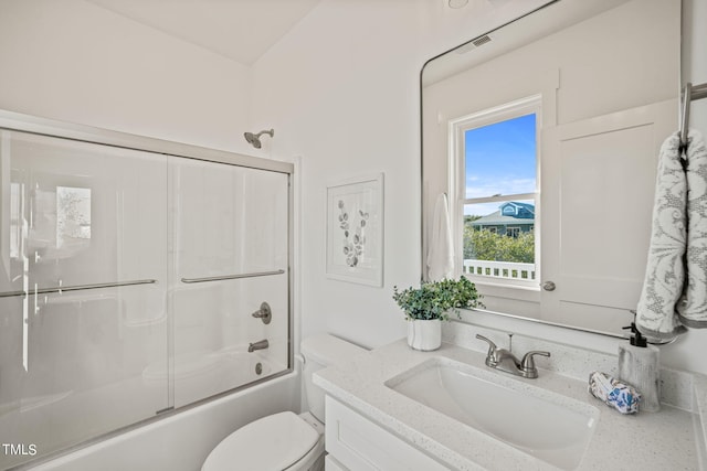 full bathroom featuring vanity, bath / shower combo with glass door, and toilet