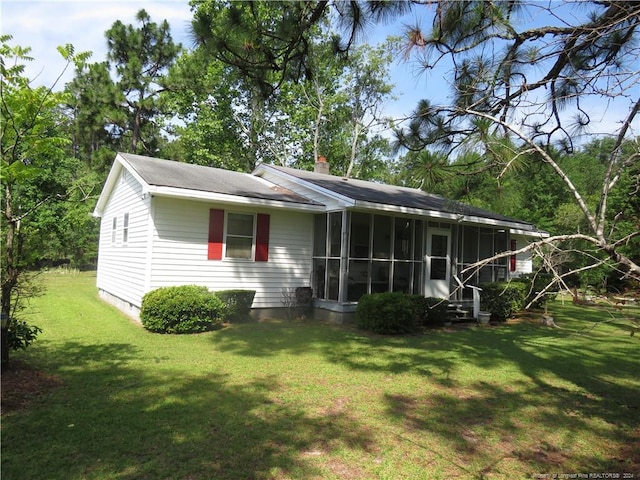 view of front of house with a front yard and a sunroom