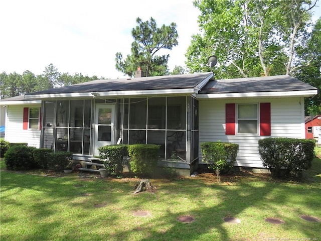 back of property featuring a yard and a sunroom