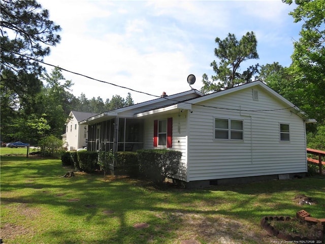 view of property exterior featuring a sunroom and a lawn