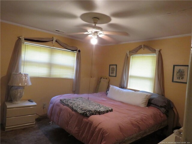 bedroom with dark carpet, crown molding, and ceiling fan