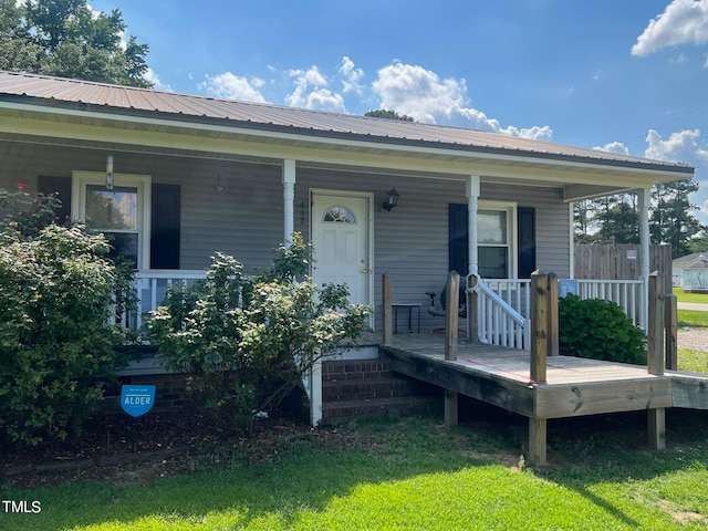 entrance to property with a yard and covered porch