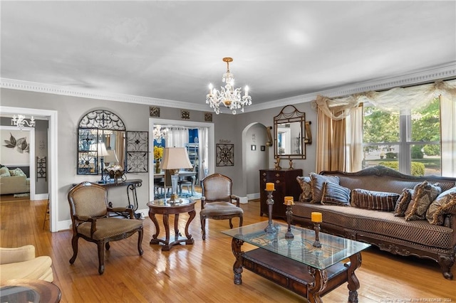 living room featuring a chandelier, light hardwood / wood-style floors, and ornamental molding