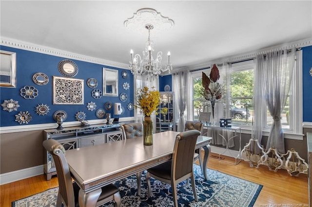 dining room featuring a chandelier, light wood-type flooring, and crown molding