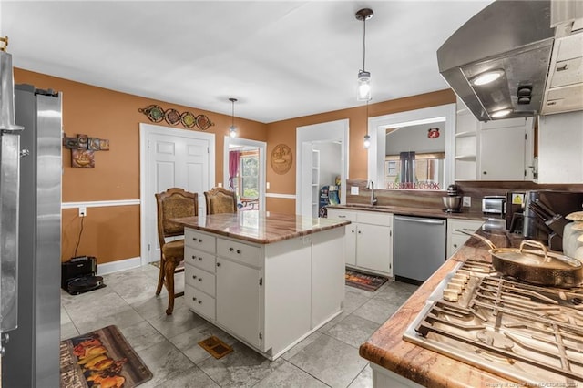 kitchen featuring stainless steel appliances, island range hood, pendant lighting, a center island, and white cabinetry