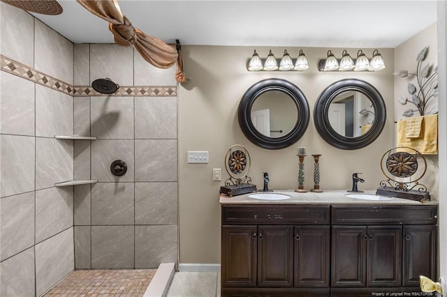 bathroom featuring a tile shower and vanity