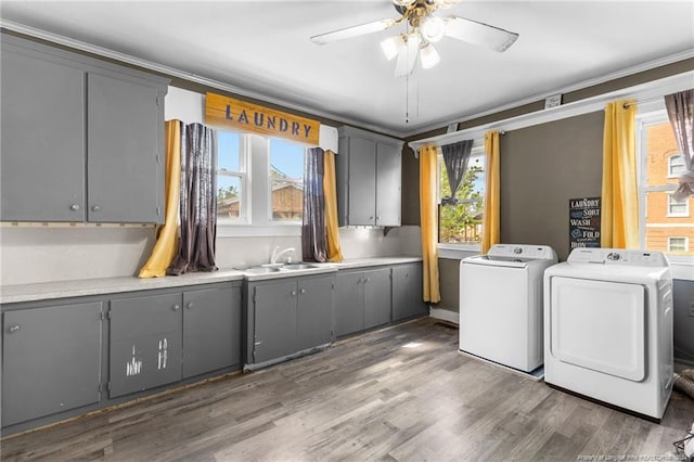 clothes washing area featuring ceiling fan, sink, dark wood-type flooring, cabinets, and washer and dryer