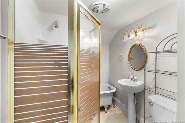 bathroom with a washtub, vaulted ceiling, and toilet