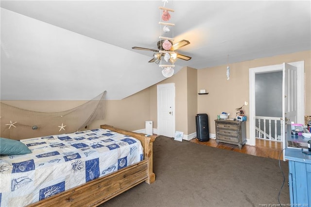 bedroom with dark colored carpet, vaulted ceiling, and ceiling fan