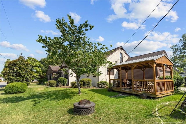 rear view of property with a gazebo, a yard, a fire pit, and a deck