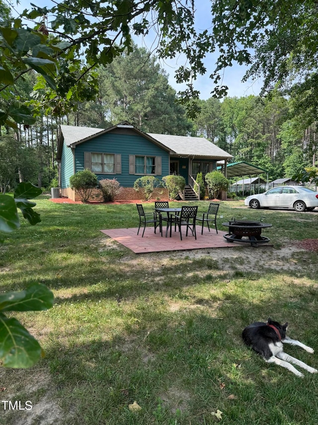 view of yard featuring a fire pit and a carport