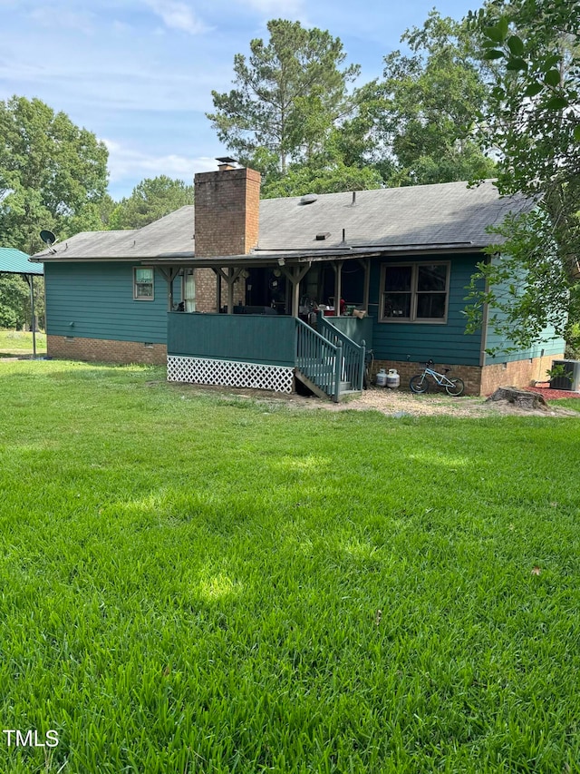 rear view of house featuring a yard