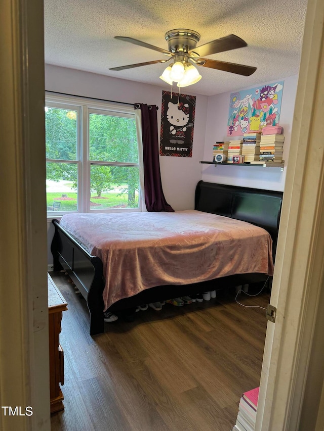 bedroom featuring ceiling fan, a textured ceiling, and hardwood / wood-style flooring