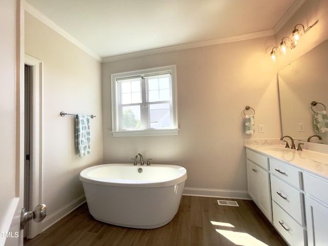 bathroom with hardwood / wood-style flooring, crown molding, and a tub to relax in