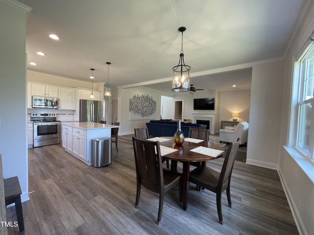 dining area featuring dark hardwood / wood-style floors, ceiling fan, and ornamental molding