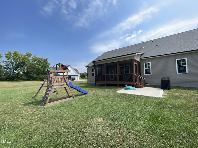 exterior space with a playground, a lawn, a patio area, and a sunroom