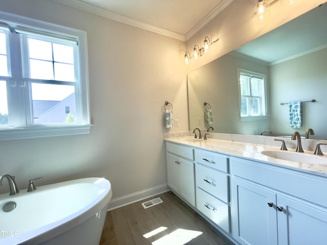 bathroom featuring hardwood / wood-style flooring, vanity, a tub to relax in, and crown molding