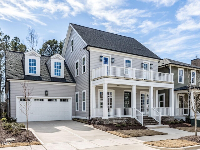 view of front of property featuring a shingled roof, covered porch, a balcony, a garage, and driveway