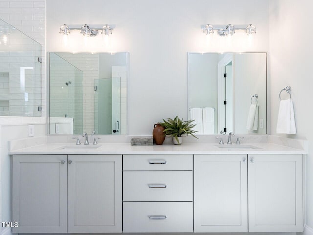 full bath with double vanity, a stall shower, and a sink