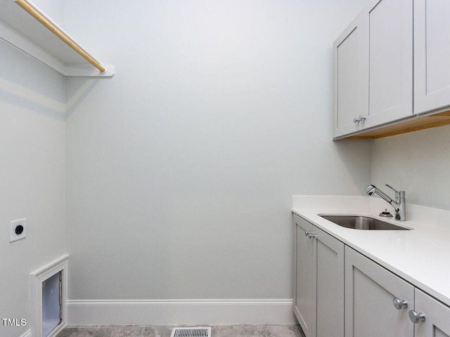 washroom with visible vents, baseboards, cabinet space, hookup for an electric dryer, and a sink