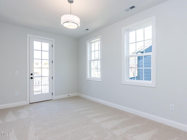 unfurnished room with baseboards, visible vents, and light colored carpet