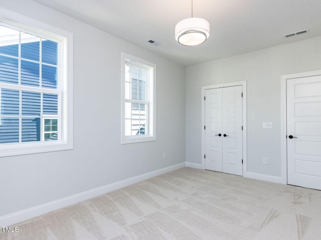 unfurnished bedroom featuring visible vents, carpet floors, baseboards, and a closet