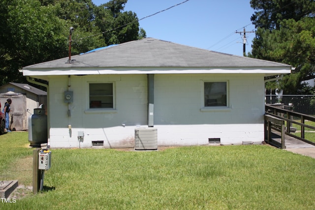 view of front of property featuring a front yard and central AC